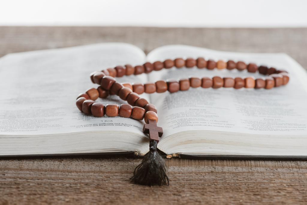 Nahaufnahme der Heiligen Bibel mit Perlen auf Holztisch - Foto, Bild