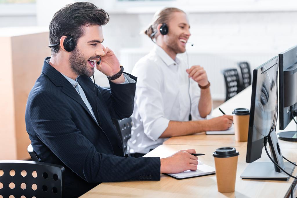 a férfi call center szereplője fejhallgatók munkahelyen hivatalban oldalnézete - Fotó, kép