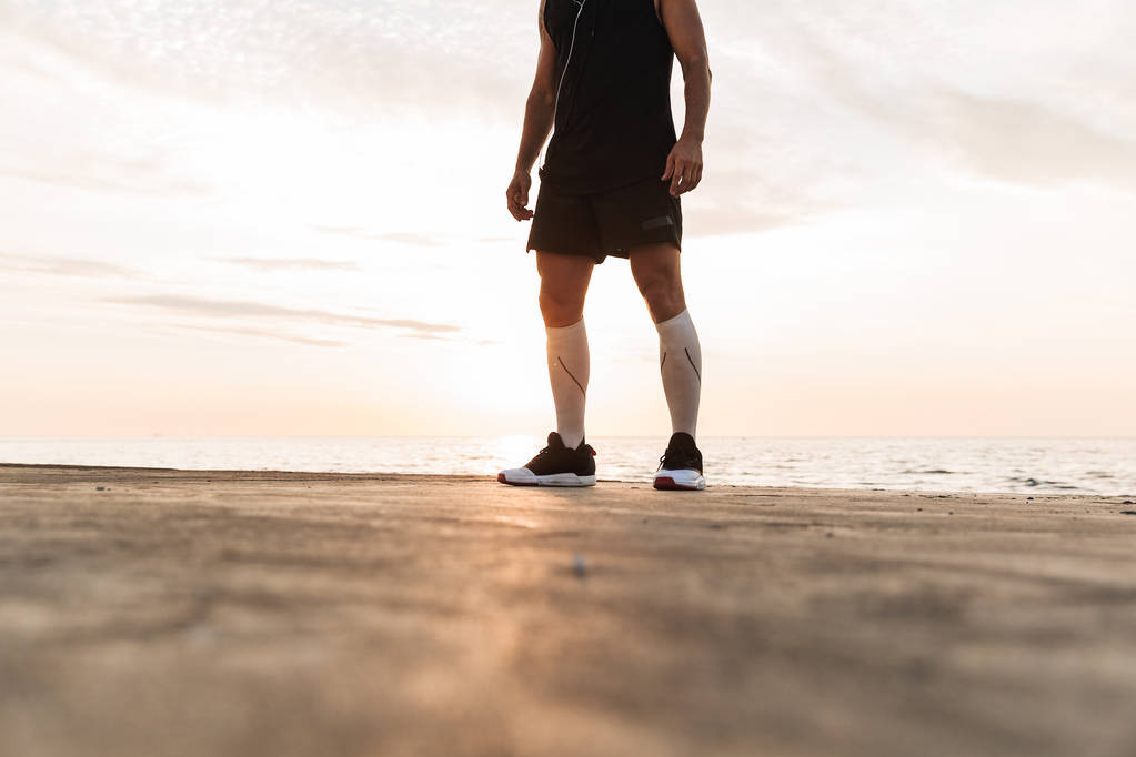 Foto recortada de un joven deportista fuerte al aire libre en la playa
. - Foto, imagen