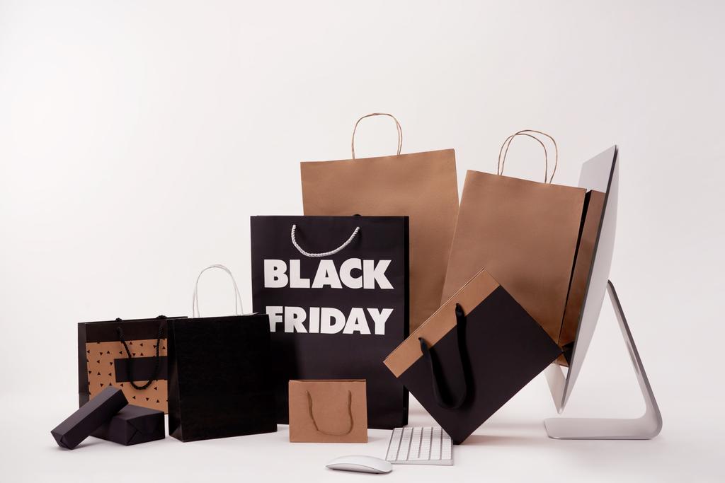 vista laterale di computer e scatole con shopping bag con cartello nero venerdì su bianco
 - Foto, immagini