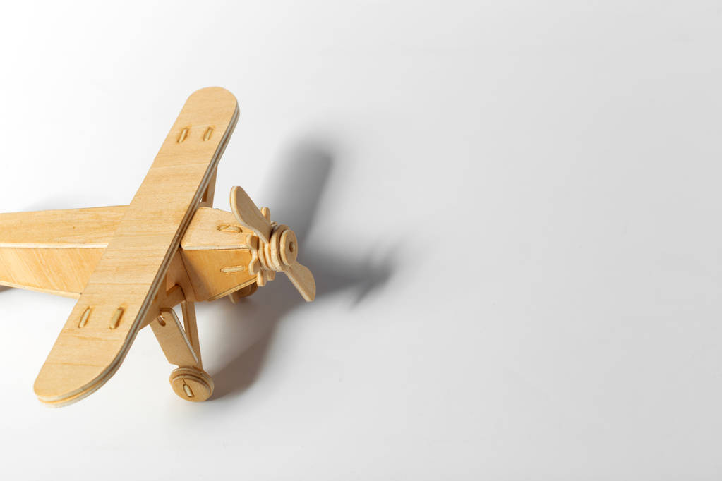 primo piano di aeroplano giocattolo in legno isolato su sfondo chiaro
  - Foto, immagini