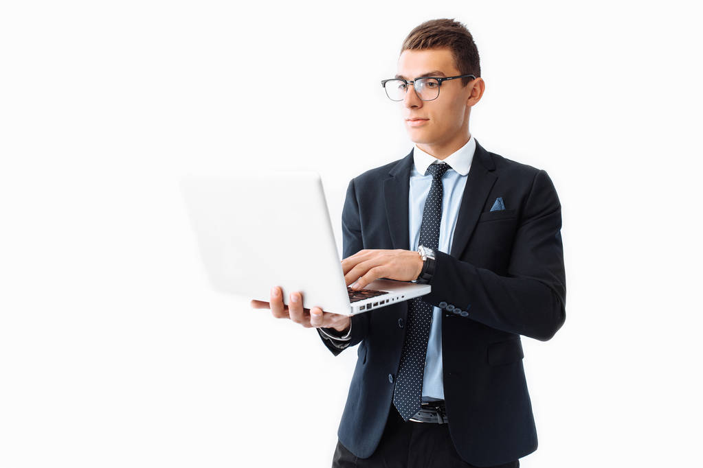 Hombre de negocios seguro con gafas, joven hombre de negocios guapo en un traje que trabaja en un ordenador portátil, sobre un fondo blanco
 - Foto, imagen