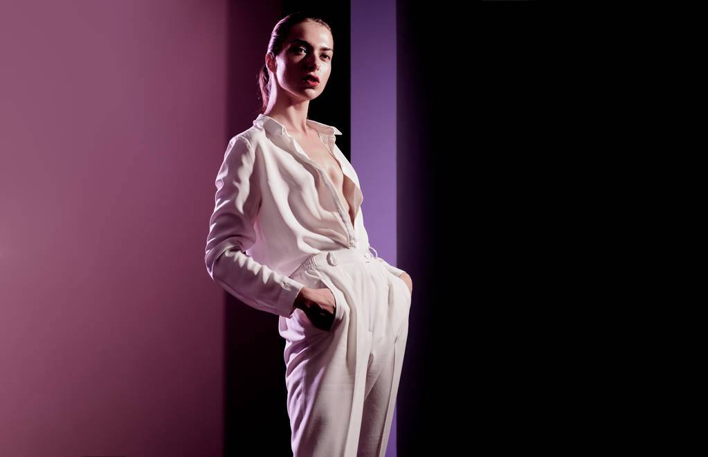 Mode Kopierraum. trendige Frauenkleidungskonzept attraktives Modell in einem stilvollen weißen Anzug vor rosa Hintergrund. Mode und eleganten Stil im Frühjahr. Kopierplatz für Ihre Werbeinhalte. - Foto, Bild