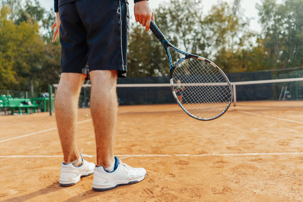 Nahaufnahme eines Mannes mit Schläger beim Warten auf Ballaufschlag auf dem Tennisplatz. - Foto, Bild