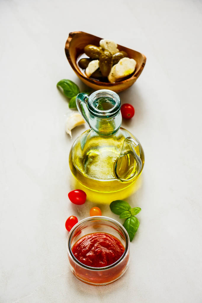 Ιταλική μαγειρική συστατικά. Σάλτσα ντομάτας, ελιές, μοτσαρέλα, φύλλα βασιλικού και λάδι - Φωτογραφία, εικόνα