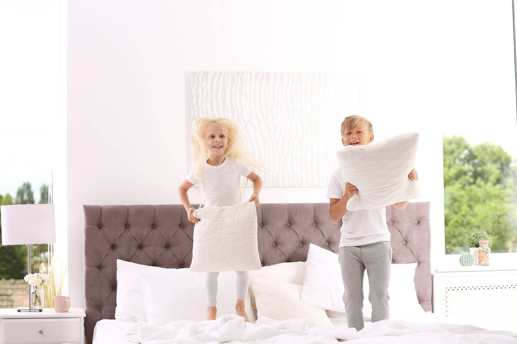Šťastné děti s polštáři skákání na posteli doma - Fotografie, Obrázek