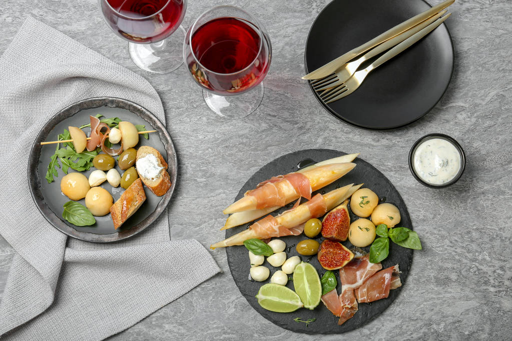Plat lag samenstelling met meloen en prosciutto voorgerecht geserveerd op tafel - Foto, afbeelding
