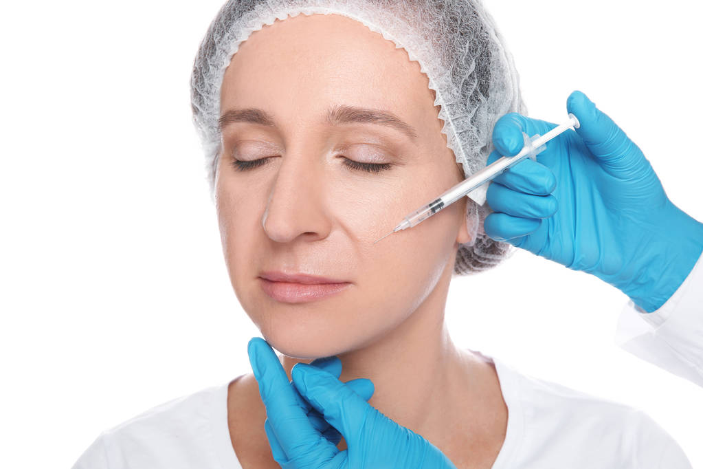 Olgun kadın yüz enjeksiyon beyaz zemin üzerine alma. Kozmetik cerrahi kavramı - Fotoğraf, Görsel