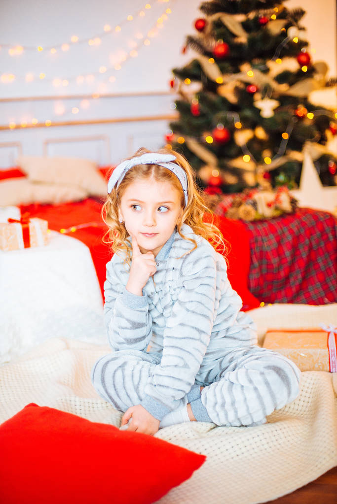 Μικρό κορίτσι με τις πυτζάμες στο πρωί Χριστουγέννων. Καλά κορίτσι Christmas.Little χαίρεται για το δώρο Χριστουγέννων - Φωτογραφία, εικόνα