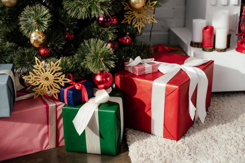 δώρο κουτιά κάτω από το χριστουγεννιάτικο δέντρο με στολίδια στο δωμάτιο - Φωτογραφία, εικόνα