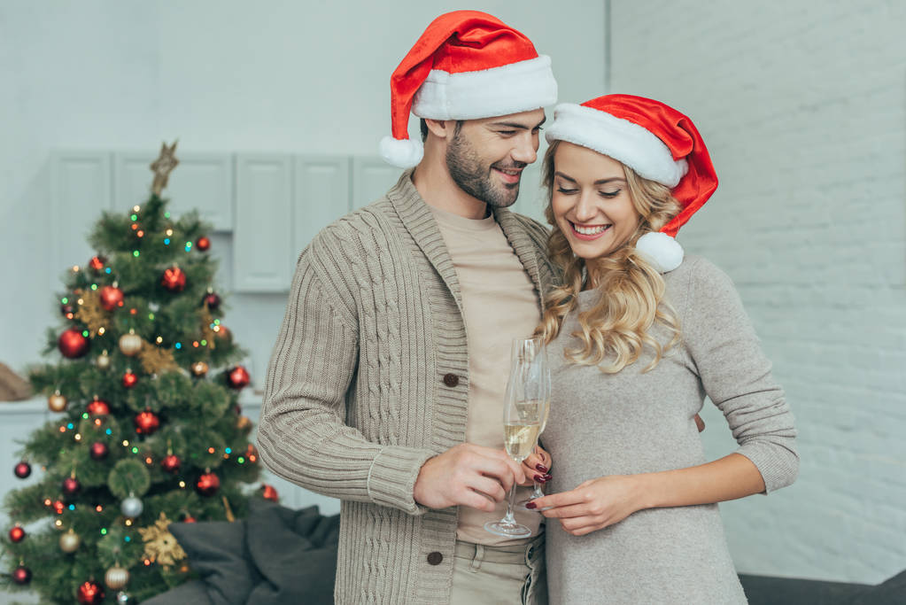 mutlu genç çift şampanya ile Noel ağacı önünde evde gözlük - Fotoğraf, Görsel