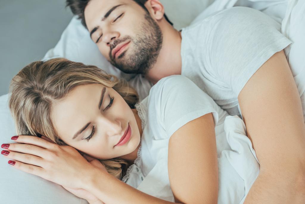 Крупным планом красивая молодая пара спит вместе в постели дома
 - Фото, изображение