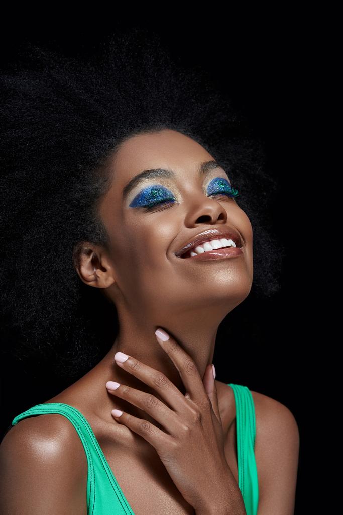 retrato do modelo americano africano sorridente com sombras azuis brilhantes dos olhos isoladas no preto
 - Foto, Imagem