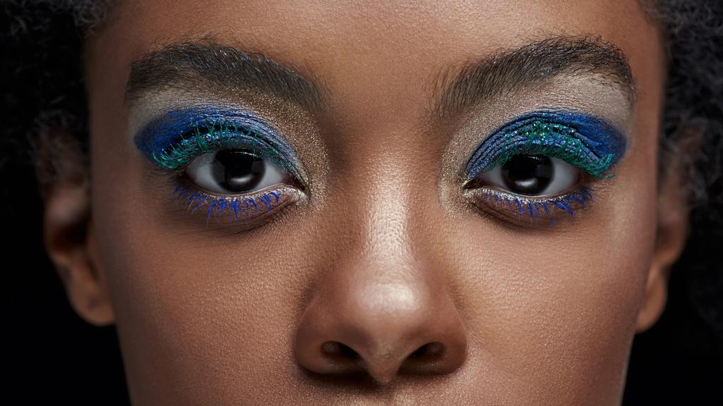 foto recortada de mujer afroamericana con sombras de ojos azules mirando a la cámara aislada en negro
 - Foto, Imagen