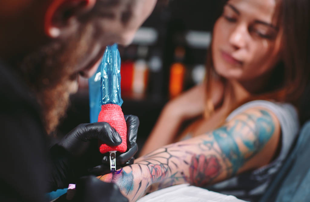 Професійний художник татуювання робить татуювання на руці молодої дівчини
. - Фото, зображення