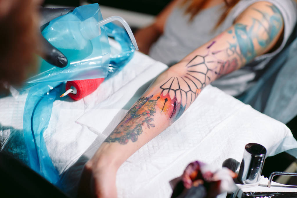 Tatuaggio professionale artista fa un tatuaggio sulla mano di una giovane ragazza
. - Foto, immagini