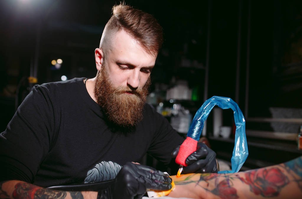 tatoueur professionnel fait un tatouage sur la main d'une jeune fille
. - Photo, image