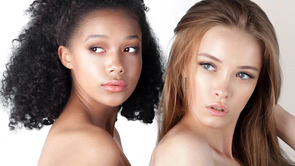 Niñas adolescentes caucásicas y africanas de cerca. Cuidado de la piel y maquillaje. Retrato de belleza de raza mixta
 - Foto, Imagen