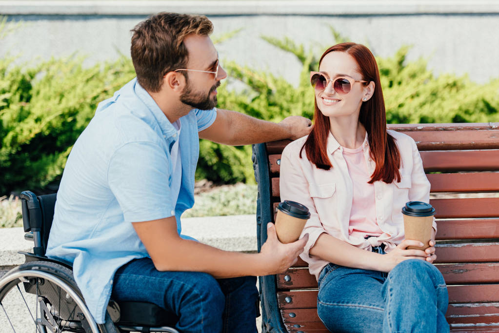 красивый парень в инвалидной коляске и девушка с кофе, чтобы смотреть друг на друга снаружи
 - Фото, изображение