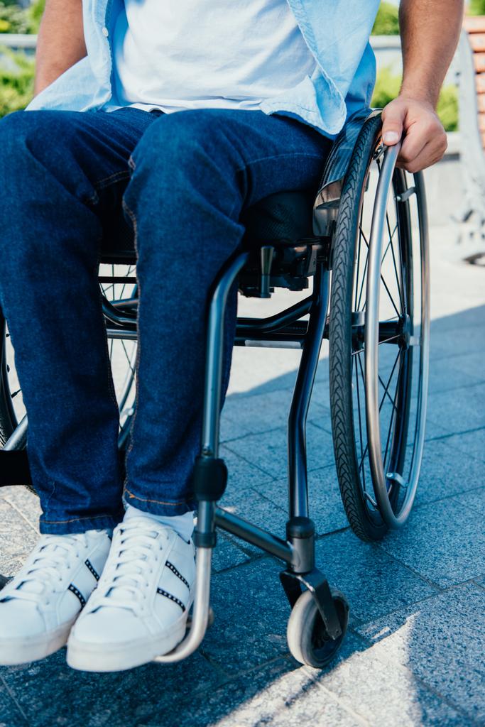 imagem cortada do homem usando cadeira de rodas na rua
 - Foto, Imagem