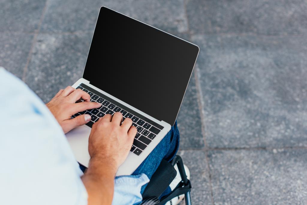 imagem cortada do homem em cadeira de rodas usando laptop com tela em branco na rua
 - Foto, Imagem