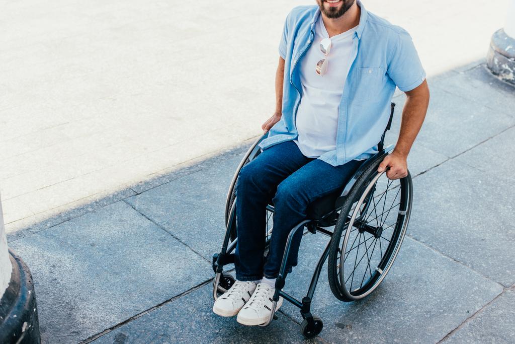 обрізане зображення людини, що використовує інвалідне крісло на вулиці
 - Фото, зображення