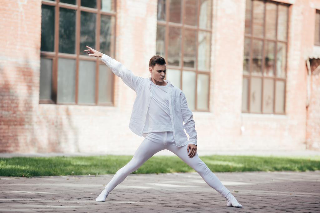 handsome young dancer performing modern dance on street  - Photo, Image