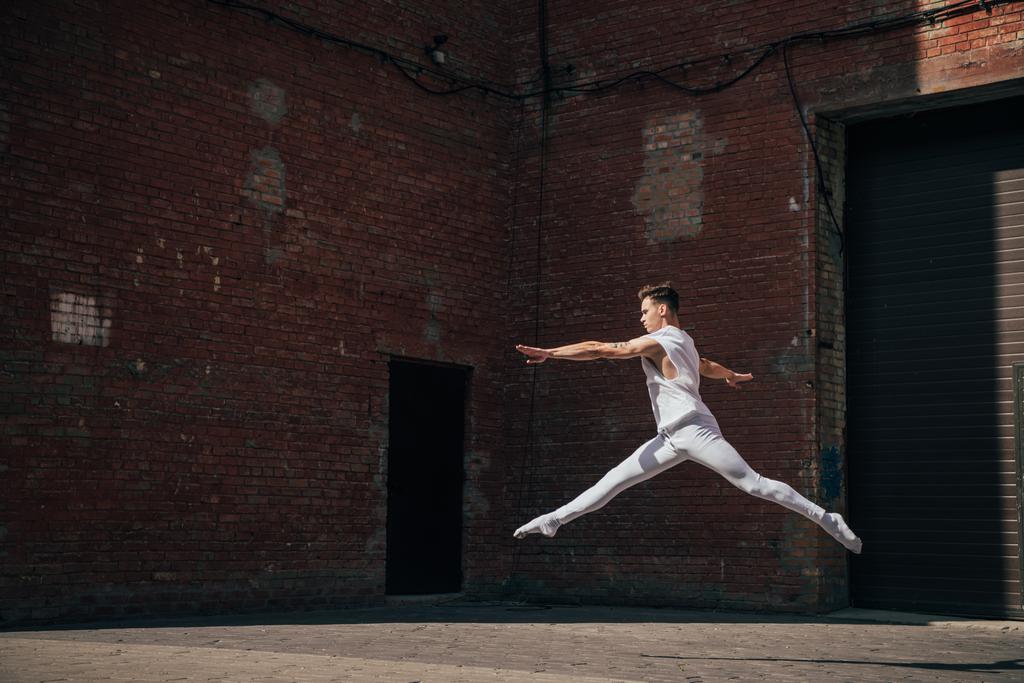 νέοι μπαλέτου χορευτής στο άλμα σε δρόμο της πόλης   - Φωτογραφία, εικόνα