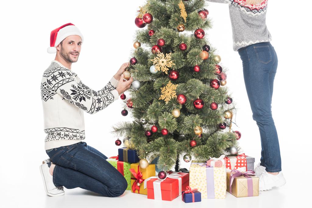 partial view of couple in sweaters decorating christmas tree together isolated on white - Photo, Image