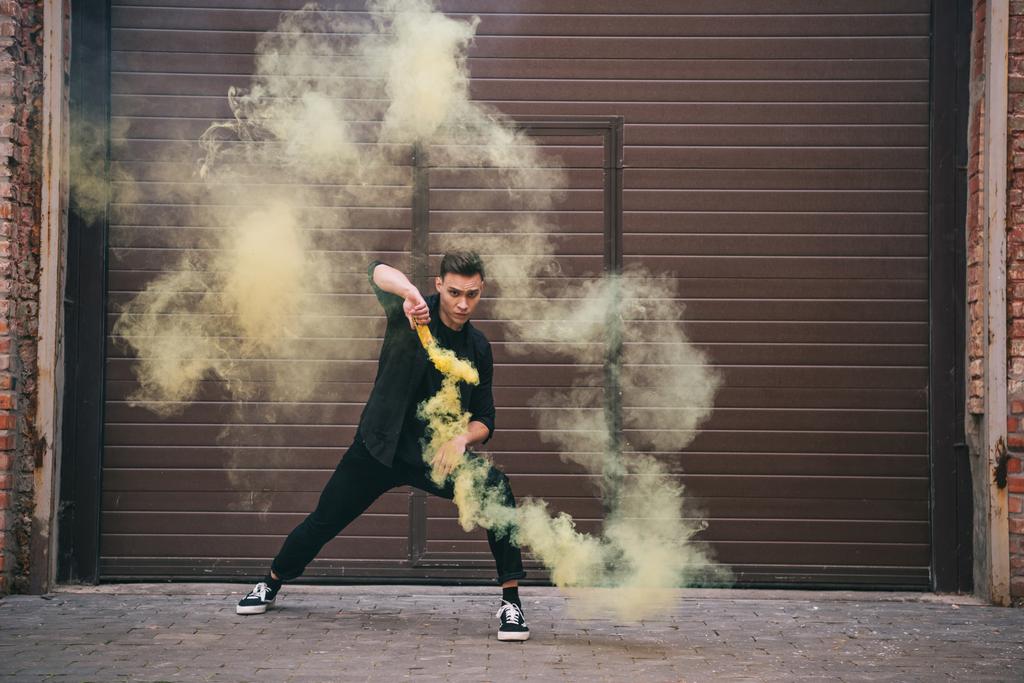 young male contemporary dancer in yellow smoke on urban city street  - Photo, Image