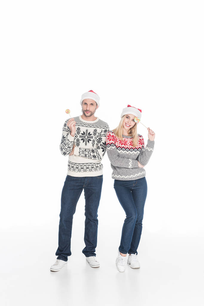 caucasian couple in santa claus hats with lollipops isolated on white - Photo, Image