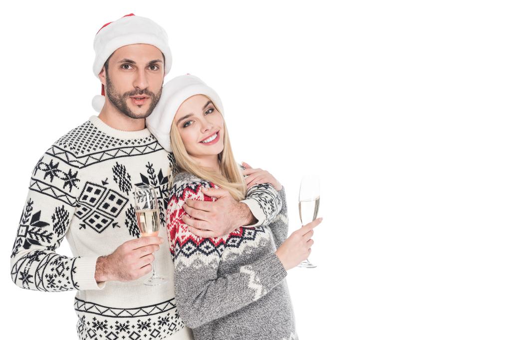 portrait of smiling couple in santa claus hats with glasses of champagne isolated on white - Photo, Image