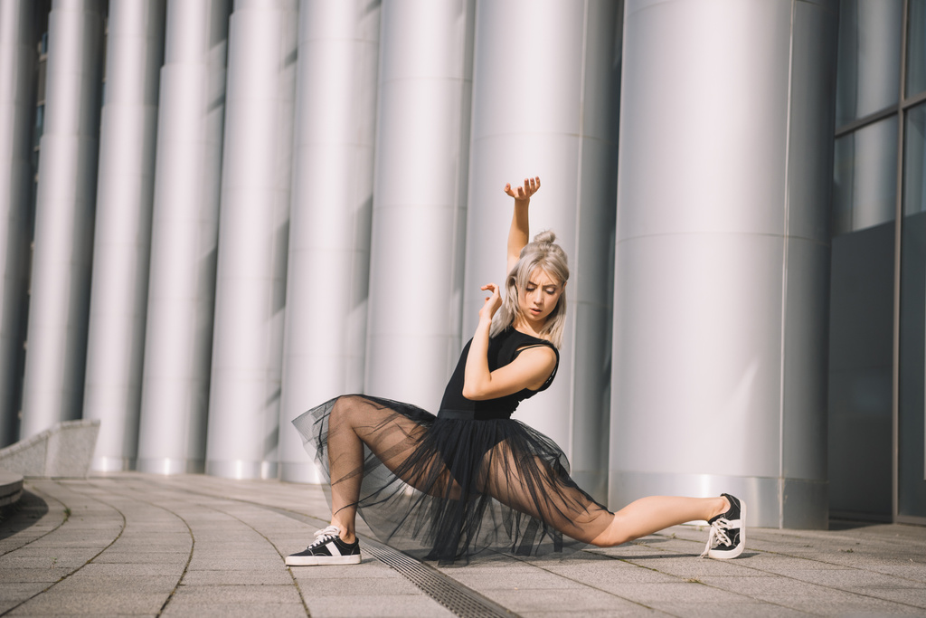 beautiful young ballerina in black skirt dancing on street  - Photo, Image