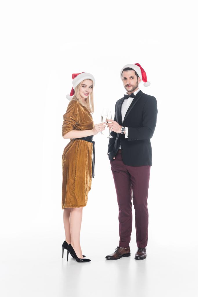 puolella näkymä muodikas pari joulupukki hatut clinking lasit samppanjaa eristetty valkoinen
 - Valokuva, kuva