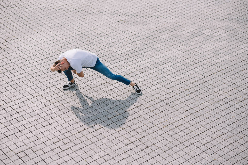 vista de ángulo alto del joven bailando en la calle de la ciudad
  - Foto, imagen