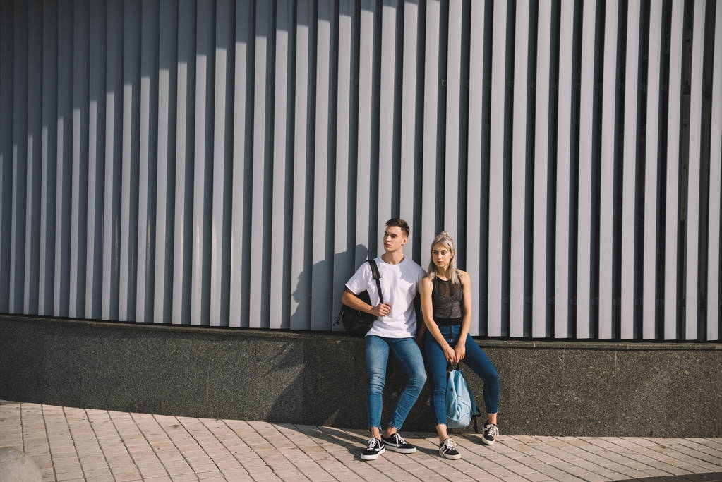 schönes junges Paar mit Rucksäcken, die zusammen auf der Straße stehen  - Foto, Bild