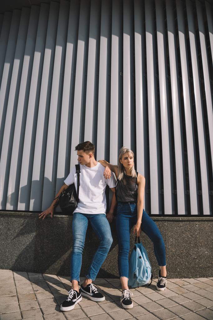 full length view of stylish young couple standing together on city street  - Photo, Image