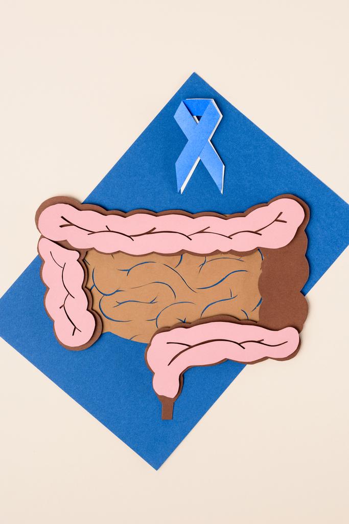 vista superior de la cinta azul de la conciencia del cáncer de próstata y el intestino grueso humano en azul con beige
 - Foto, Imagen