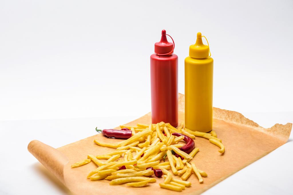 Close-up shot van heerlijke frietjes met peper, ketchup en mosterd op wit - Foto, afbeelding