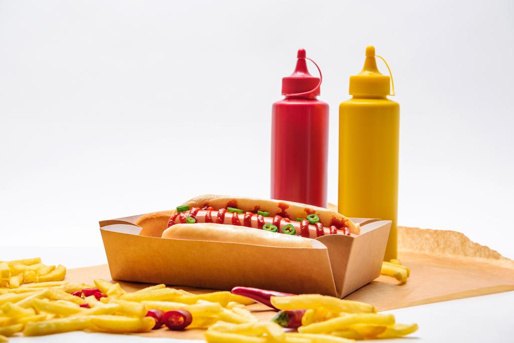 κοντινή λήψη ενός hot dog με τηγανητές πατάτες σε λευκή επιφάνεια - Φωτογραφία, εικόνα