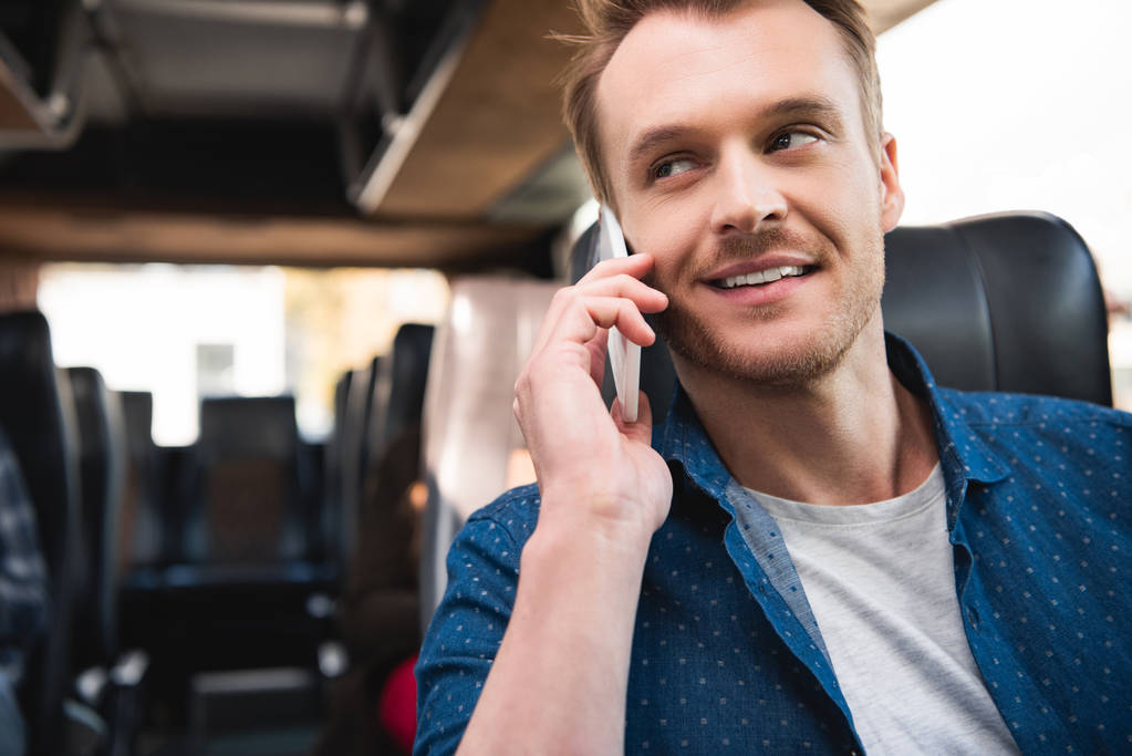 feliz viajero masculino hablando en el teléfono inteligente durante el viaje en autobús
 - Foto, Imagen
