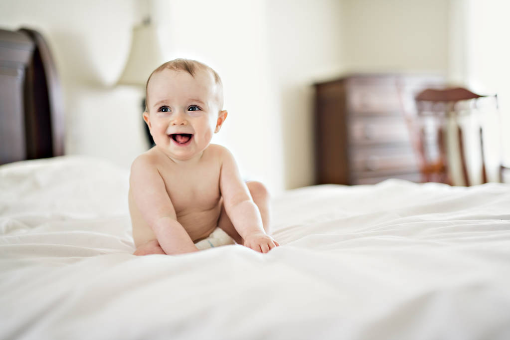 Portret van een baby op het bed - Foto, afbeelding