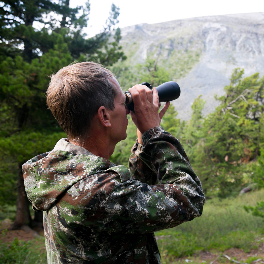 男は山の頂上に望遠鏡で見えます。観光客は山に双眼鏡で見える. - 写真・画像