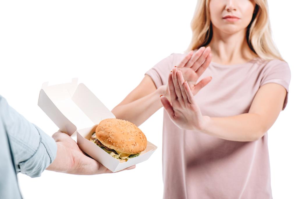 περικομμένη εικόνα της γυναίκας απορρίπτει ανθυγιεινά burger που απομονώνονται σε λευκό - Φωτογραφία, εικόνα