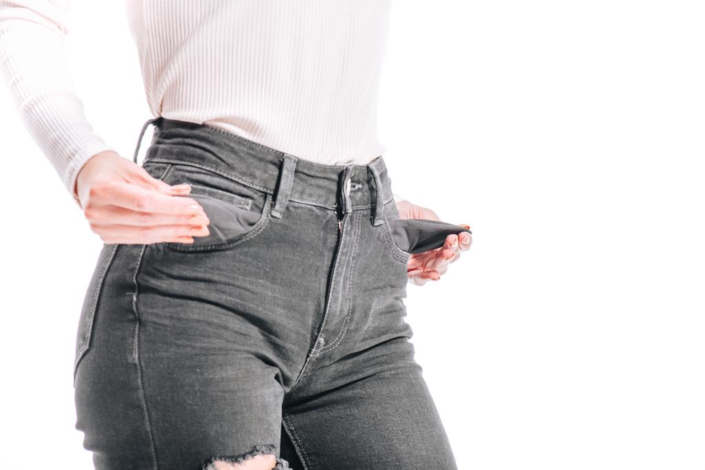 обрезанное изображение девушки с пустыми джинсовыми карманами, изолированными на белом
 - Фото, изображение