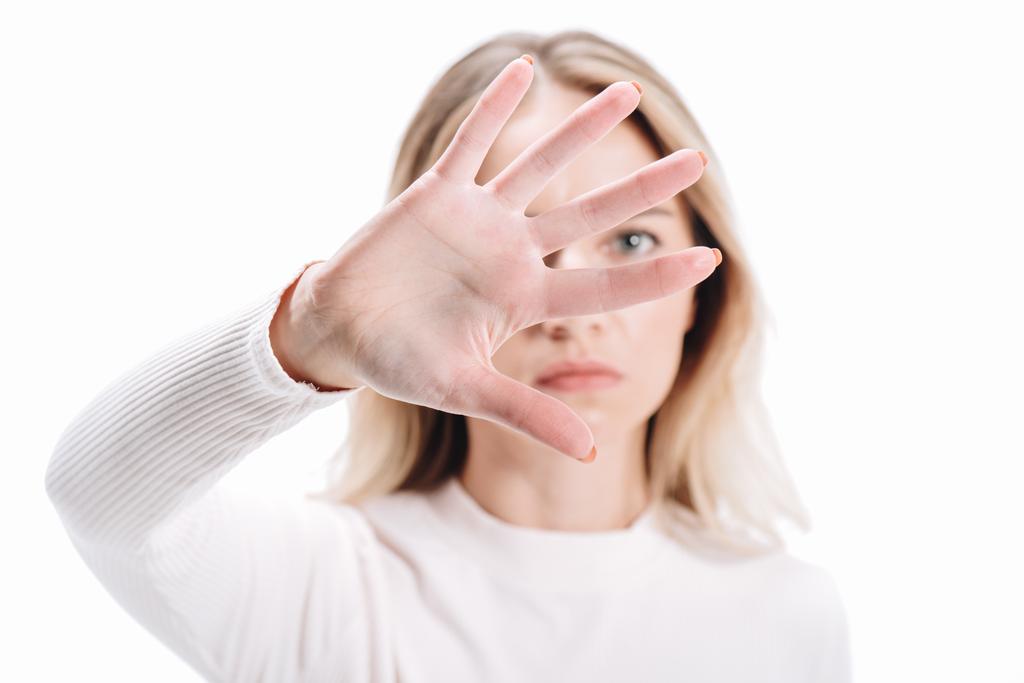mulher loira mostrando sinal de parada e olhando para a câmera isolada no branco
 - Foto, Imagem