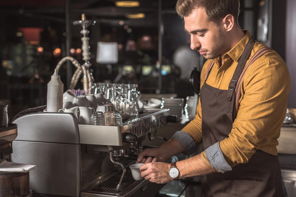 όμορφος νεαρός barista προετοιμασία καφέ με μηχανή του καφέ σε καφετέρια - Φωτογραφία, εικόνα