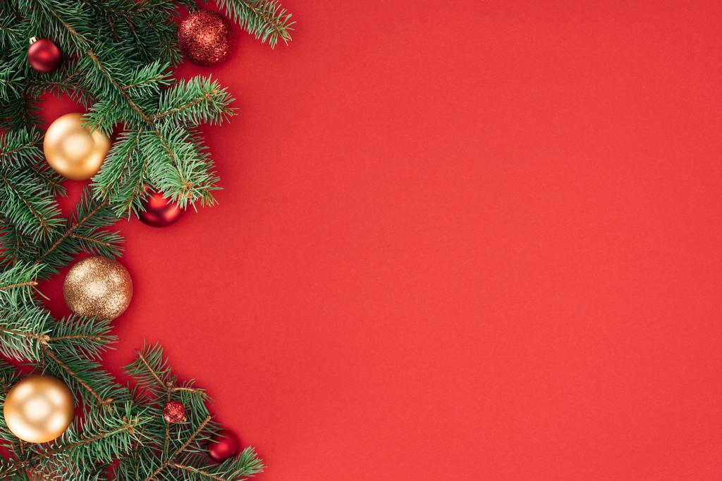 düz lay çam ağacı dalları ile kırmızı izole kırmızı ve altın Noel topları ile - Fotoğraf, Görsel