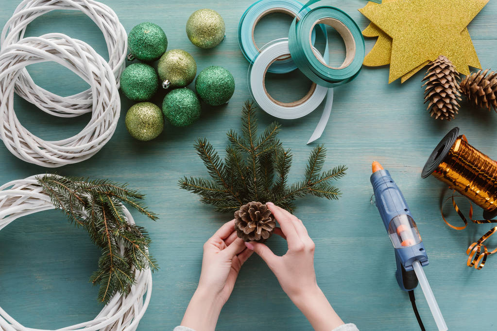 részleges kilátás nyílik nő, ami a kézzel készített Karácsonyi koszorú a kék fa felülettel - Fotó, kép