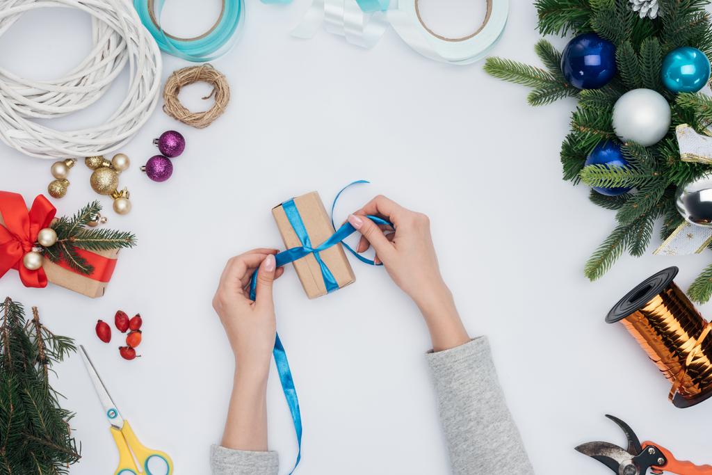 plan recadré de femme enveloppant cadeau de Noël avec ruban bleu isolé sur blanc
 - Photo, image